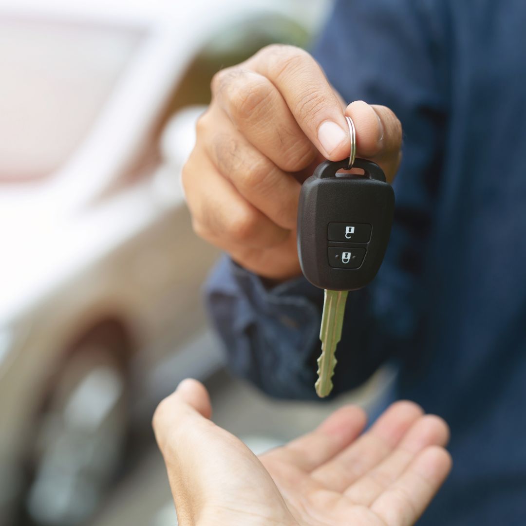 salesman handing car key over to owner